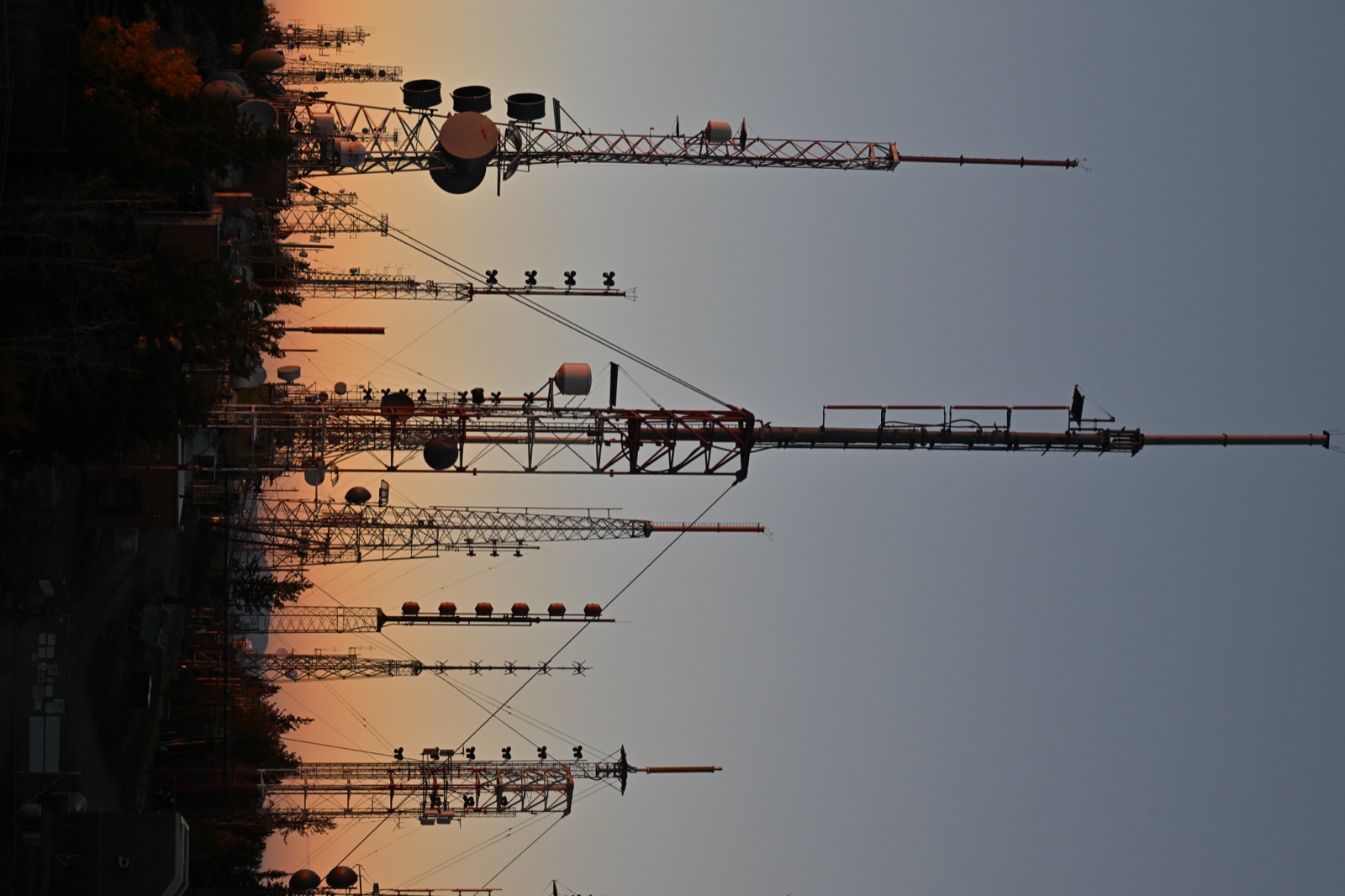 Representative radio towers silhouetted against a sunset on Sandia Peak
